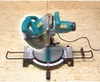 A miter saw is placed on a wooden surface. Podgląd zdjęcia produktu