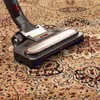 A close-up shot of a vacuum cleaner head on an oriental rug. Produktbild-Vorschau