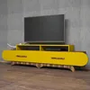 A modern yellow TV stand with wooden accents, featuring a television on top, set against a textured gray wall and a wooden floor. Produktbild-Vorschau