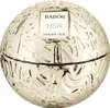 A close-up, studio shot of a spherical, gold-colored cosmetic jar with a textured surface and a white label. Voir les images du produit