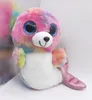 A plush toy seal with rainbow colors and glittery tail, sitting on a white surface. Anteprima dell’immagine prodotto