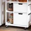 A close-up view of a white kitchen cart with two drawers and shelves containing food items. Náhled obrázku produktu