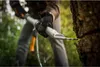 A person using a wood splitting tool on a tree trunk in a forest setting. Produktbild-Vorschau