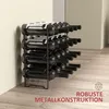 A black metal wine rack filled with wine bottles, placed against a light-colored wall and on a wooden floor. Náhled obrázku produktu