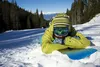 A person lying in the snow with a snowboard. Anteprima dell’immagine prodotto
