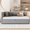 A gray upholstered daybed with a pull-out trundle bed is shown in a well-lit room with shelves in the background. Anteprima dell’immagine prodotto
