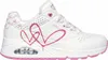 A side view of a white sneaker with pink heart designs. Voir les images du produit