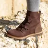 A close-up of a brown boot on rocky terrain. Voir les images du produit