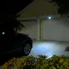 A dark image of a car parked in front of a house at night, illuminated by a solar-powered light. Produktbild-Vorschau