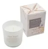 A scented candle and its packaging are displayed against a white background. Voir les images du produit