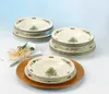A set of Christmas-themed soup bowls stacked on a table, with a napkin and gold ribbon in the foreground. Produktbild-Vorschau