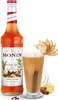 A bottle of Monin Winter Spice syrup and a glass of a beverage garnished with apple slices and a cinnamon stick. Podgląd zdjęcia produktu