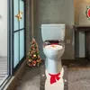 A Christmas-themed bathroom with a snowman toilet seat cover and matching rug, a small decorated Christmas tree, and a star ornament on a window. Anteprima dell’immagine prodotto