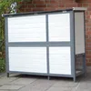 A wooden rabbit hutch with white and gray panels, set on a paved patio. Produktbild-Vorschau