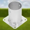 A metal post anchor with a square base and a cylindrical top, set against a blurred background of green grass and a blue sky. Anteprima dell’immagine prodotto