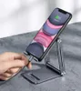 A hand is plugging a charging cable into a smartphone that is placed on a foldable phone stand. Náhľad obrázku produktu