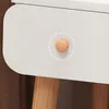 Close-up of a white drawer with a round wooden knob, on a table with wooden legs. Anteprima dell’immagine prodotto