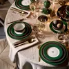 A beautifully set dining table for a festive occasion, possibly Christmas, with plates, cutlery, glasses, and decorative elements. Produktbild-Vorschau