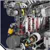 A close-up view of a complex mechanical assembly, likely a model engine, with various gears, pistons, and a belt-driven system. Náhľad obrázku produktu