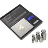 A digital scale with three pearls on its platform, next to several calibration weights, against a white background. Produktbild-Vorschau