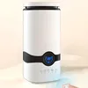 A white humidifier with a black accent band and a blue digital display sits on a light-colored surface. Voir les images du produit