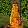 A large piece of salmon is being cooked over an open fire on a metal plank. Náhľad obrázku produktu