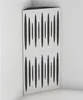 A corner acoustic bass trap panel with a white front and black cutouts, placed in a room corner. Podgląd zdjęcia produktu