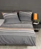 A neatly made bed with striped bedding and pillows. Produktbild-Vorschau