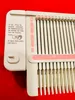 A close-up of a knitting machine with instructions and markings. Produktbild-Vorschau