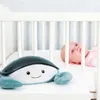 A stuffed crab toy is placed in front of a baby in a crib. Náhled obrázku produktu