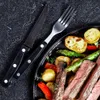 A close-up view of a steak dinner with cutlery. Produktbild-Vorschau