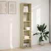 A tall, narrow bookshelf filled with books and decorative items, placed against a white wall with sunlight casting shadows. A large potted plant is to the right. Produktbild-Vorschau