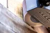 A close-up of a sanding belt on a satining machine being used on a wooden surface. Produktbild-Vorschau