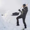 A man is shoveling snow in a snowy outdoor environment. Produktbild-Vorschau
