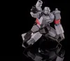 A gray robot toy with red and purple accents is posed on a reflective black surface. Podgląd zdjęcia produktu