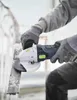 A person wearing gloves is using an angle grinder to cut metal. Produktbild-Vorschau
