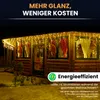 A wooden cabin decorated with icicle lights at night. Produktbild-Vorschau