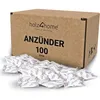A cardboard box with the brand name and product details, with many small fire starters spilled in front of it. Produktbild-Vorschau