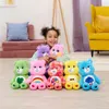 A young girl is sitting on the floor surrounded by several colorful stuffed bears. Anteprima dell’immagine prodotto