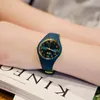 A person's arm wearing a watch, resting on a book. Produktbild-Vorschau