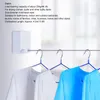 A retractable clothesline mounted on a wall, with several t-shirts hanging on it. Podgląd zdjęcia produktu