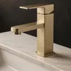 A modern gold faucet is shown on a marble countertop. Náhľad obrázku produktu