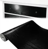 A roll of black wood-grain contact paper is shown below a close-up of drawer fronts with the same finish. Produktbild-Vorschau