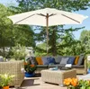 A patio set with a large umbrella, sofa, chairs, and coffee table, surrounded by greenery and flowers. Produktbild-Vorschau