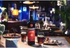 A bottle of Ramazzotti Amaro liqueur is displayed on a table with two glasses, berries, and a piece of chocolate. Produktbild-Vorschau