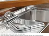 A close-up view of a chrome kitchen faucet with a pull-out spray, installed in a stainless steel sink. Náhled obrázku produktu