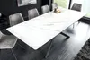 A modern dining table with a white marble-patterned top and a dark metal base, surrounded by grey upholstered chairs, set in a dining room with dark walls and a large window. Produktbild-Vorschau