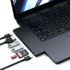 A Satechi Pro Hub Slim connected to a laptop, with various accessories like USB drives and SD cards nearby. Produktbild-Vorschau