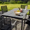 An outdoor dining set with a table and chairs, set on a wooden deck with a grassy background. Produktbild-Vorschau