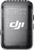 A close-up, front-facing view of a black and transparent DJI Mic TX transmitter with its internal circuitry visible. Náhled obrázku produktu